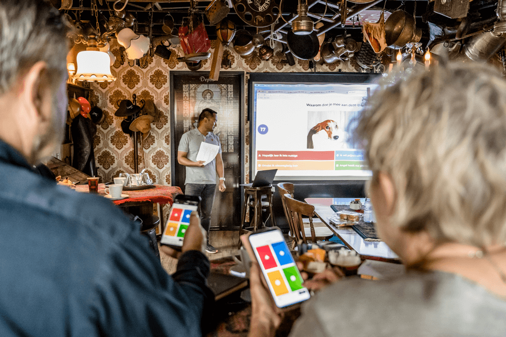 Deelnemers met smartphones tijdens een pub quiz